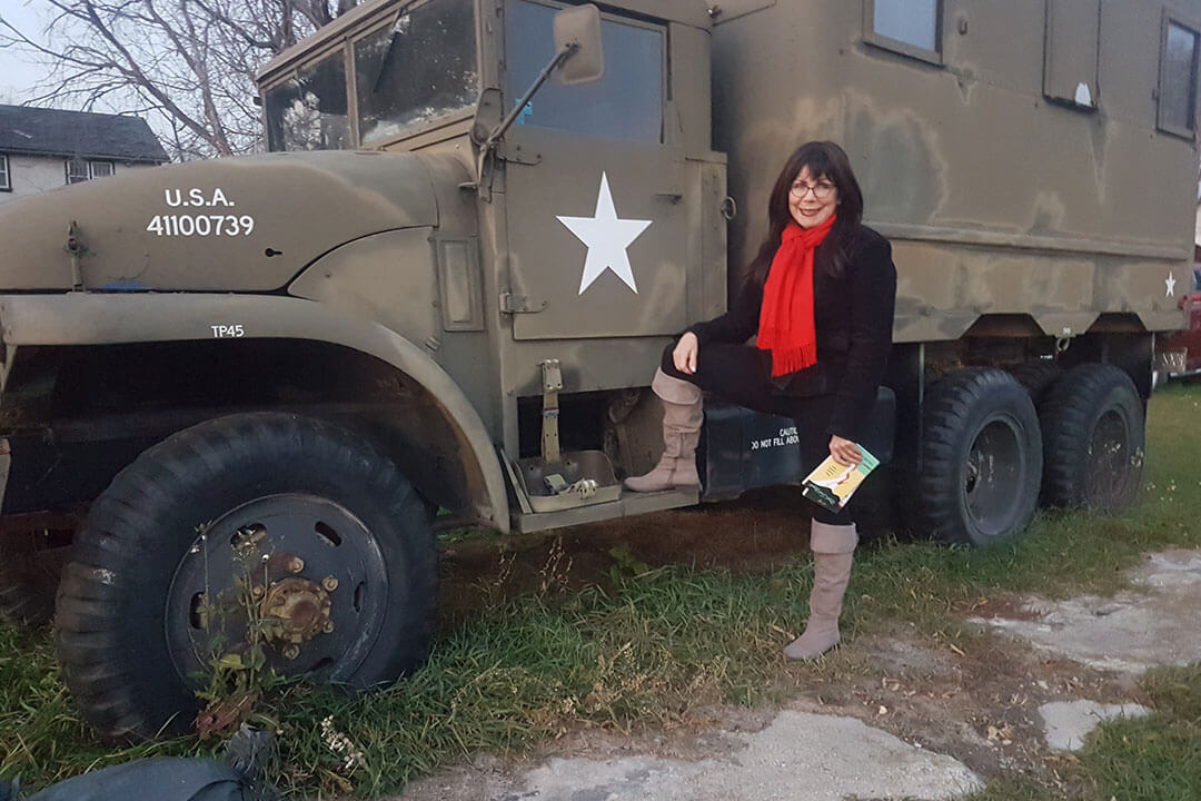 Helen standing beside a military truck